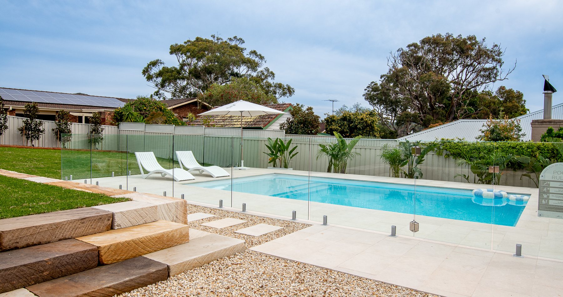 The heated pool, lawn and fire pit area in the back yard at Illaroo House